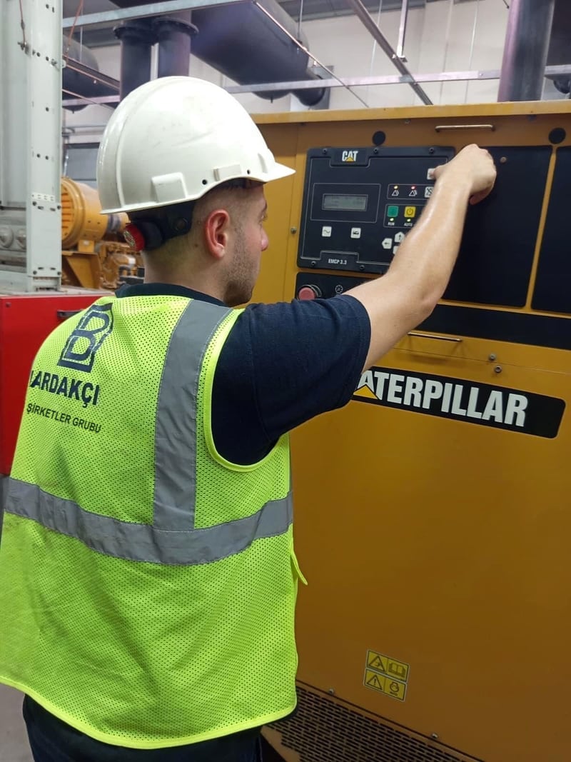 Jeneratör kontrol panelinde bakım yapan teknisyen